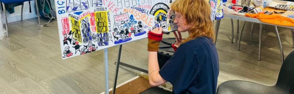 Artist Mollie Ray capturing ideas about The Coro in a comic art display