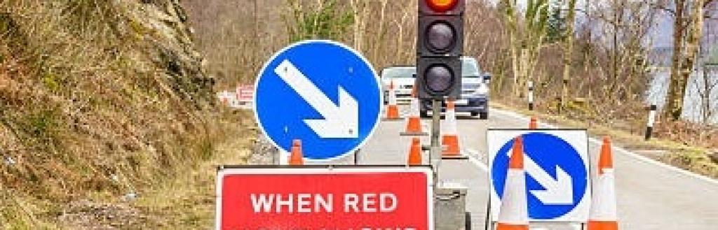 Cars waiting at traffic lights at roadworks.