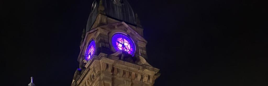 Kendal Town Hall clock face illuminated purple