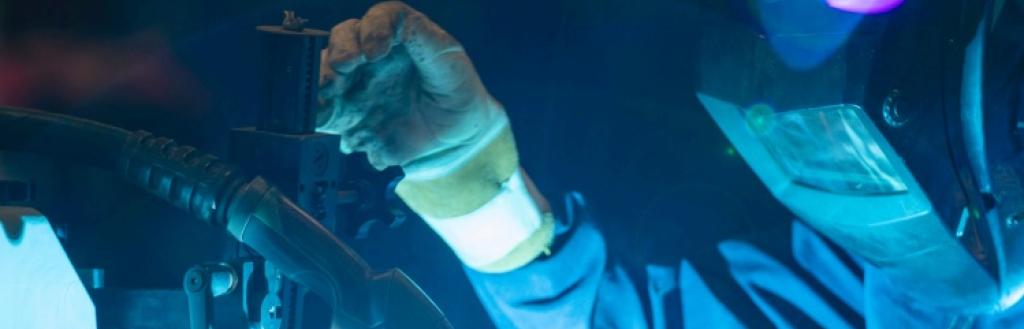 A person in a welding mask welding.