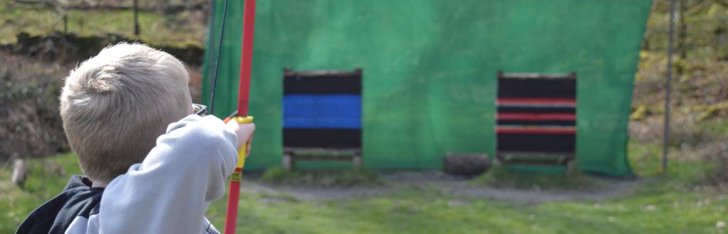 Child learning archery at holiday club