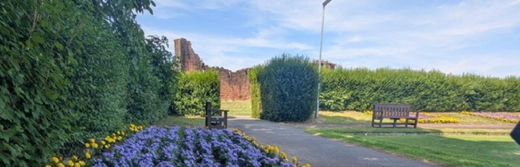 Flowers in Penrith Castle Park with the castle ruins in the background