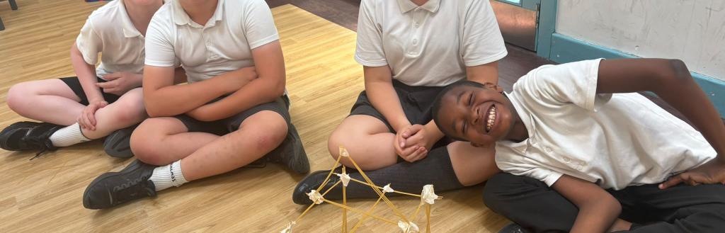 Children smiling with their pasta, STEM building creations