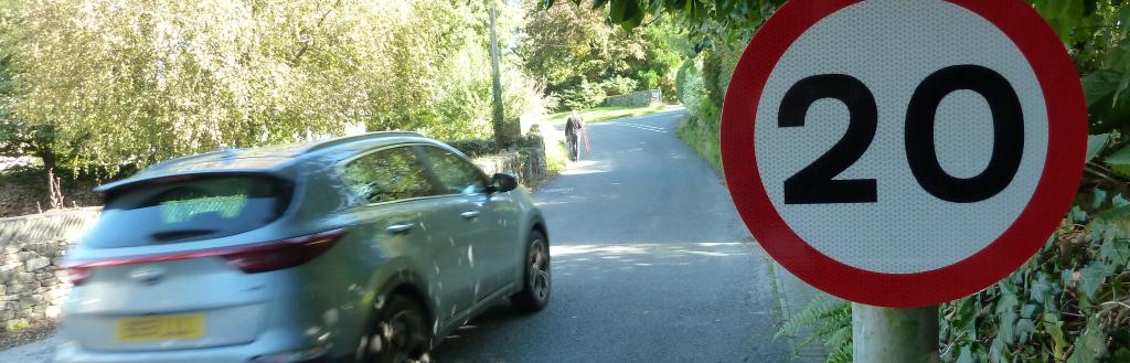 Sign showing 20mph speed limit with car passing by