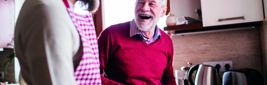 young man chopping food with older man in the kitchen